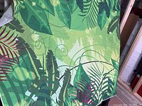 Photo of jungle-themed 5x7 backdrop with leafy green foliage pattern and some visible markings.