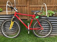 Full side view of red Peugeot mountain bike showing frame, saddle, and wheels