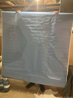 Blue vinyl photography backdrop held up for display, showing wrinkles and size