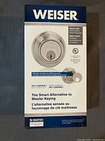 Front of box showing Weiser SmartKey security deadbolt lock image and features, mentioning concealed keyhole and great for multi-family/rentals