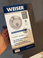 Front view of sealed Weiser door lock box showing branding, key control feature, and suitability for rentals.
