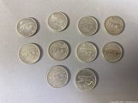 Ten Canadian sterling silver quarters arranged in two rows, showing the reverse side with a running cougar design and the dates 1867-1967.