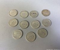 Top down view of all 11 Canadian sterling silver quarters from 1867-1967 showing the side with cougar/panther image and dates.