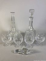 Group photo of two crystal decanters and four brandy snifter goblets, showcasing overall condition and layout.