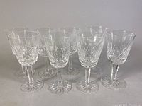 Front view showing all 8 crystal cordial goblets with detailed cut pattern and starburst base.