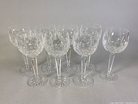 Group of eight goblets arranged in two staggered rows on gray background