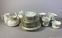 Full view of the vintage Royal Stafford tea set including teapot, creamer, sugar bowl, 6 teacups, 6 saucers and plates stacked in front.