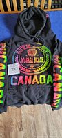 Front view of black ladies hoodie showing large colourful Wasaga Beach Canada print with vibrant text on body and sleeves.