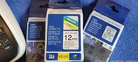 Image of three sealed 12mm tape cassette packs for Brother label maker in various colors