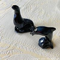 Two dark blue glazed Blue Mountain Pottery animal figurines on cream textured fabric, showing size and shape.