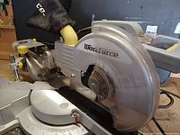 Side view of Workforce mitre saw showing main unit, blade guard, and clamp on handle.