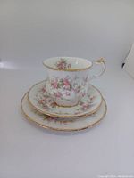 Teacup, saucer, and dessert plate arranged stacked to show pattern and set.