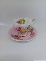 Pink Queen Anne fine bone china teacup and saucer set with multicolored floral designs and gold accents.