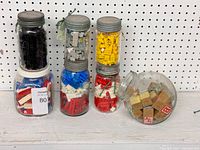 Five antique Mason Crown glass jars filled with assorted vintage Lego pieces and wooden alphabet blocks,varying in color and shape.