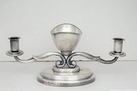 Front view of the silver plated centerpiece showing the central bowl elevated on a stepped base with two curved candle arms on either side.