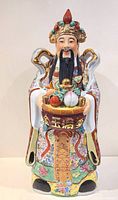 Front view of large ceramic Chinese Immortal figurine showing the detailed face, headdress, and basket of symbolic items.