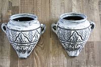 Front view of two ceramic wall planters showing embossed detail and distressed finish.