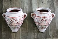 Top view of two ceramic wall pockets showing decorative patterns and dual handles