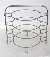 Front view of vintage metal pie rack with four circular tiers and handle