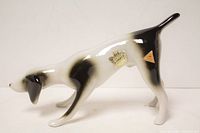 Side view of glossy porcelain pointer dog figurine showing color and Royal Dux factory marks on left side.