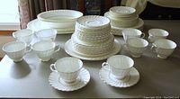 Full view of the 57-piece dinnerware set arranged on a table showing cups, saucers, plates, bowls, and platters.