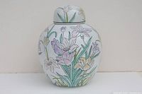 Side view of the porcelain vase with floral motif in pastel colors, showcasing the vase's curved shape and lid.