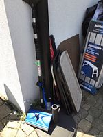 View showing blue car brush with telescopic handle and black folded mats