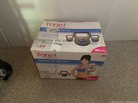 Photo of the Tone 4 Fitness kettlebell set packaging showing kettlebells and DVD with weight and fitness model image.