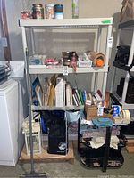 White plastic shelving unit with four shelves shown with various items on it, including books, craft supplies, and other small objects, but contents not included in sale.