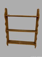 Three-shelf hanging shelf made of curly maple wood with scalloped side edges shown against a plain background.