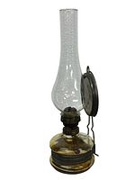 Full view of the antique hanging oil lamp showing clear chimney, brass burner, yellow glass reservoir, and hanging bracket