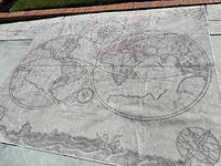 Full view of the 8x10 washable world map rug laid out on pavement showing detailed map design and muted color scheme.