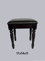 Front view of small ebony stool showing turned legs and padded black top, with dimensions 17x14x11 marked