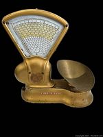 Front view of the Toledo candy scale showing the fan-shaped dial with detailed weight markings and gold-colored body.