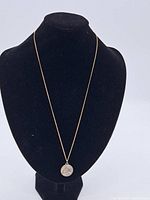 Full view of sterling silver chain with round 800 silver pendant displayed on black bust.