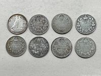 Photo showing seven Canada 10 cent silver coins, mostly George V era, including visible dates 1918, 1924, and 1930 with crowns and wreaths on reverse and a Bluenose schooner on one obverse.