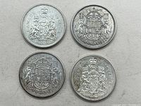Four Canadian 50 cent silver coins arranged on a flat surface, showing front and back with coat of arms and dated 1957, 1958, 1962, 1964.