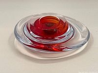 Top-down view showing the rounded clear glass outer layer with red glass inner section and hollow central opening.