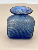 Front and side view of the hand-blown blue art glass vase showing swirling pattern and wide open flared neck