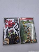 Two used PSP game cases Dead Head Fred and Daxter shown together from front.