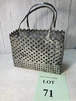 Full view of the antique woven tin basket with metal handles and scalloped edge insert.