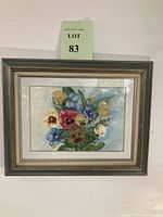 Full view of the framed floral artwork featuring pansies and lily of the valley, showing the frame and double matting
