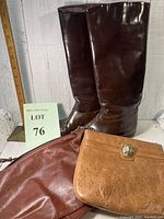 Photo of two dark brown leather boots and two leather purses, one medium brown and one light tan with a metallic clasp.