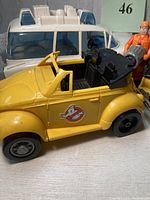 Photo showing yellow convertible Ghostbusters toy car with black interior and Ghostbusters logo on side.