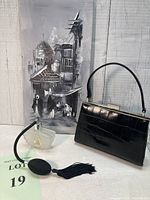 Overview of the lot, showing the vintage black croc skin patent handbag, the crystal glass perfume bottle with black bulb atomizer, and the original Egypt street scene painting in the background.