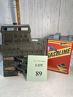 Vintage olive green toy resembling a space center building from a 1980 computer game next to a red and yellow gasoline can toy garage for cars