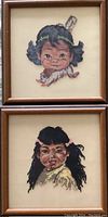 Two framed petit point portraits of young girls displayed vertically in wooden frames