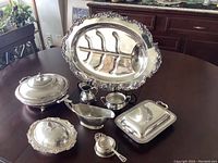 Several silver plated serving pieces arranged on a table showing design and scale