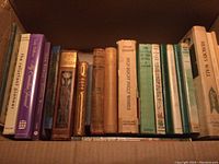 Box of mixed Canadian historical fiction and non-fiction books showing various titles and cover conditions.