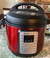 Front view of Instant Pot Viva digital pressure cooker with red and black housing and control panel visible.